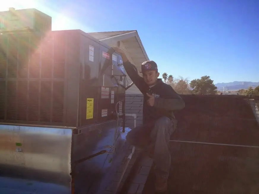 HVAC technician performing Air Duct Cleaning on a rooftop unit in Wyandotte